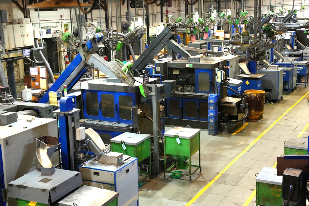 Chão de fábrica industrial com maquinário e linhas de segurança amarelas
