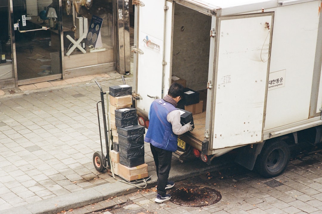 Trabalhador descarregando caixas de caminhao em doca logistica
